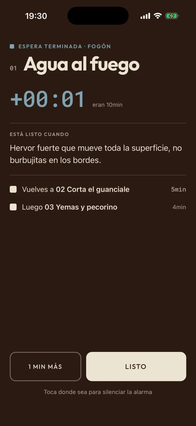 La alarma en la app: espera terminada para el agua al fuego, recién cumplidos los 10 minutos previstos. Vuelves a cortar el guanciale, 5 minutos, luego yemas y pecorino, 4; los botones dicen «1 min más» y «Listo».